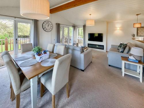 a living room with a table and chairs and a tv at The Ardle in Crieff