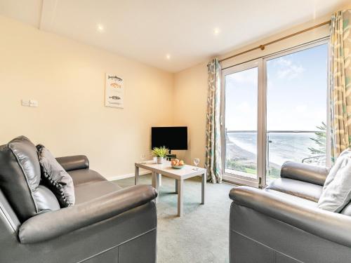 a living room with two leather chairs and a television at 11 Mount Brioni - Ukc5345 in Torpoint