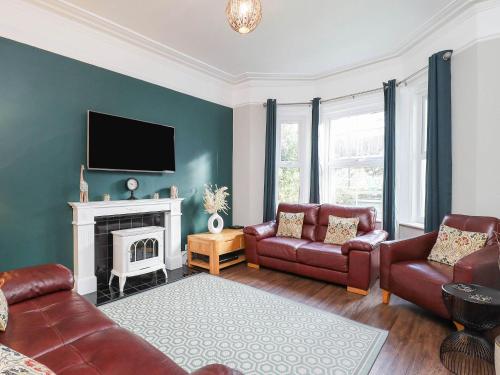 a living room with a couch and a fireplace at Kenmare Cottage in Shanklin