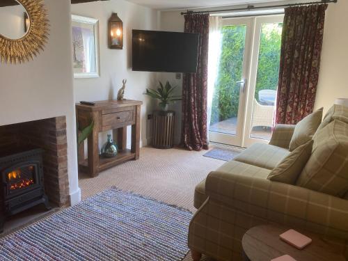a living room with a couch and a fireplace at Victory Cottage in Cottesmore