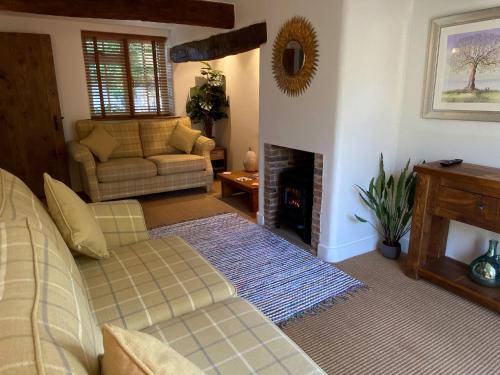 a living room with a couch and a fireplace at Victory Cottage in Cottesmore