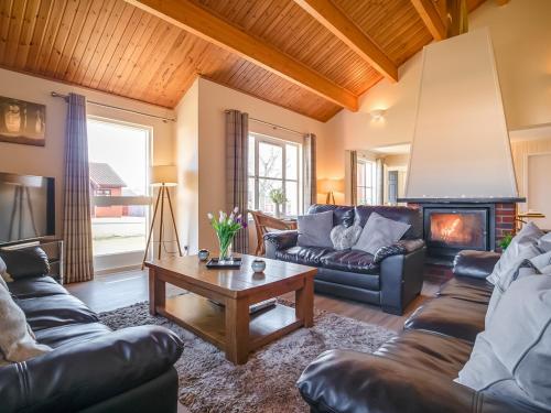 a living room with leather furniture and a fireplace at Eagle 3 Star - Ukc5056 in Aviemore