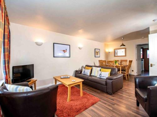 a living room with a couch and a tv at The Osprey-Ukc5062 in Aviemore