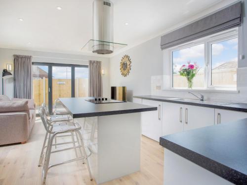 a kitchen with white cabinets and a black counter top at Northwood 2 in Broadstairs