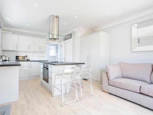 a kitchen and living room with a couch and a table at Northwood 2 in Broadstairs