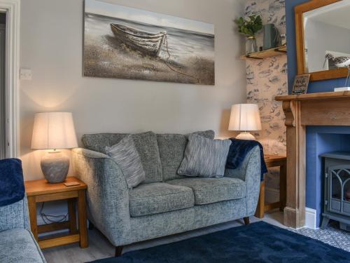 a living room with a couch and a fireplace at Curlew Cottage- Ukc5450 in Pakefield