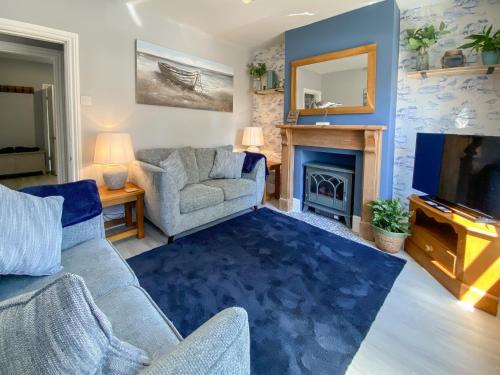 a living room with a couch and a fireplace at Curlew Cottage- Ukc5450 in Pakefield