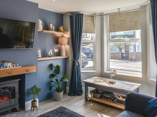 a living room with a fireplace and blue walls at Avocet - Ukc5446 in Pakefield