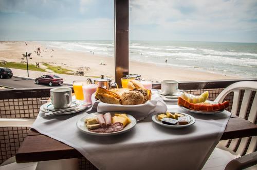 a table with food and a view of the beach at Dunas Praia Hotel in Torres