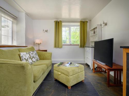 a living room with a yellow couch and a tv at The Den - Ukc4937 in West Anstey