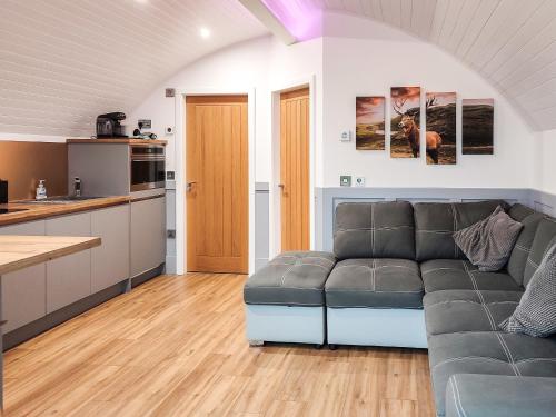 a living room with a couch and a kitchen at Knockan - Ukc6026 in Newmill