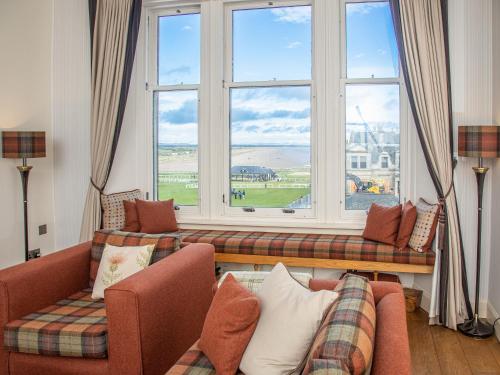 a living room with two couches and a large window at The Golf Place in St. Andrews
