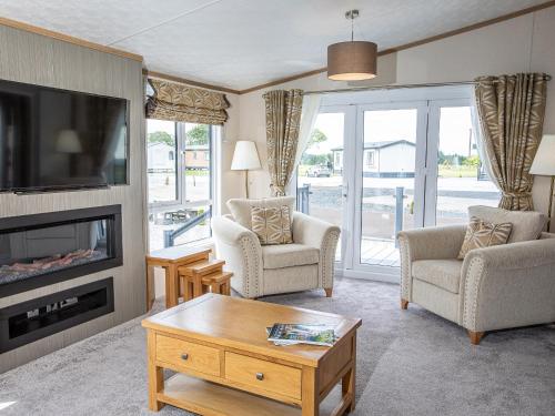 a living room with two chairs and a tv at Rivendale 7 in St. Andrews