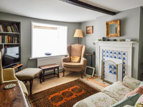 a living room with a couch and a fireplace at Grove Cottage in Yarmouth
