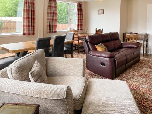 a living room with a couch and a table at Crianlarich Cottage in Fort Augustus