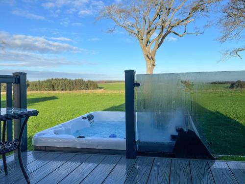 a jacuzzi tub on a deck with a tree at Knightsbridge 30 in Cameron