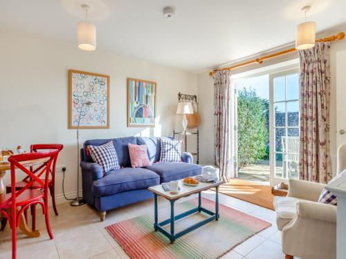 a living room with a blue couch and a table at Little Scarlett - Ukc6132 in Eastdean