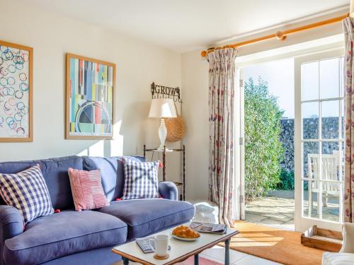 a living room with a blue couch and a table at Little Scarlett - Ukc6132 in Eastdean