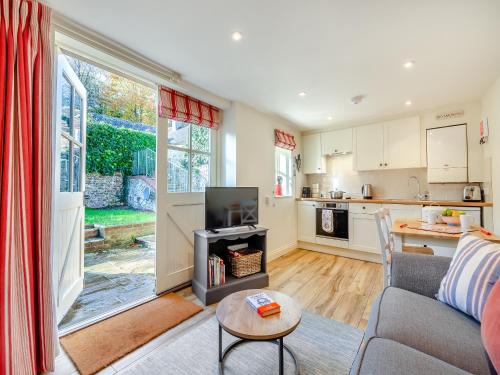 a living room with a couch and a tv and a kitchen at White Cottage - Ukc6133 in Eastdean