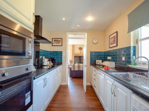 a kitchen with a sink and a stove top oven at Cairngorm View - Ukc5052 in Aviemore