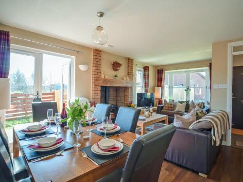 a dining room and living room with a table and chairs at Cairngorm View - Ukc5052 in Aviemore