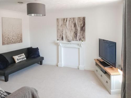 a living room with a couch and a flat screen tv at Redcot Gardens in Stamford