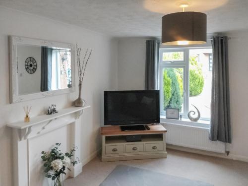 a living room with a television and a window at Redcot Gardens in Stamford