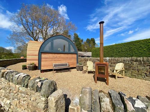 a small cabin with a window and a stone wall at Oak Tree Retreat in Dronfield