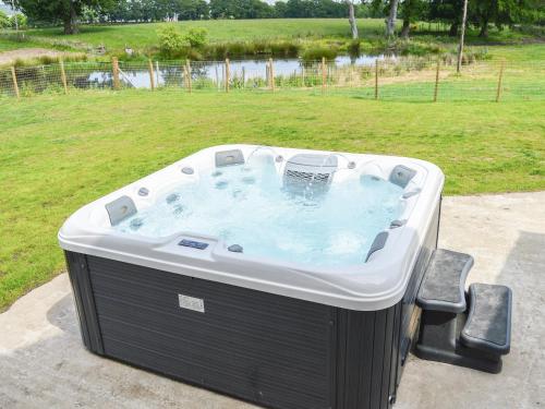 a hot tub in a yard with two chairs at The Farmhouse - Ukc6250 in Linlithgow