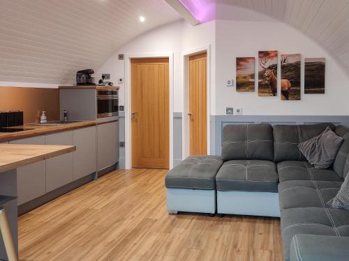 a living room with a couch and a kitchen at Meikle Balloch - Ukc6069 in Newmill