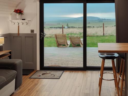 a living room with a table and a glass door at Meikle Balloch - Ukc6069 in Newmill