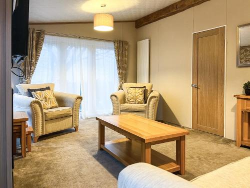 a living room with two chairs and a table at Saltire 26 in St. Andrews