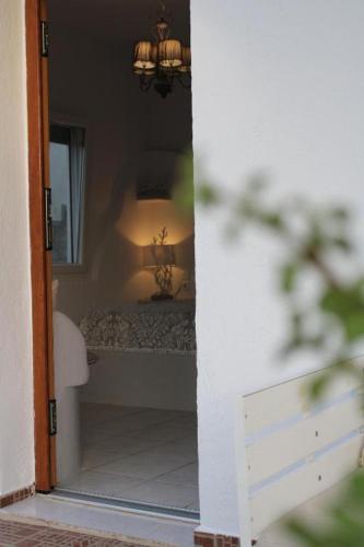 a doorway to a bedroom with a bed and a lamp at SunΚissed Suite - Pollonia Milos in Pollonia