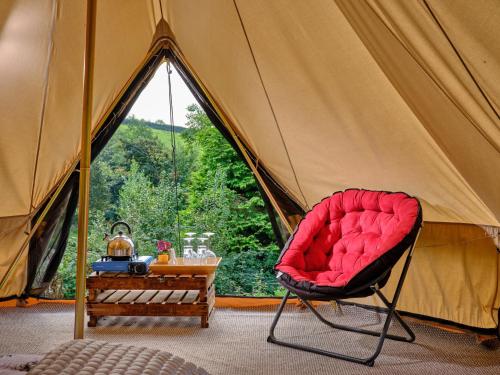 a red chair sitting in front of a tent at Cowslip- Ukc4942 in West Anstey