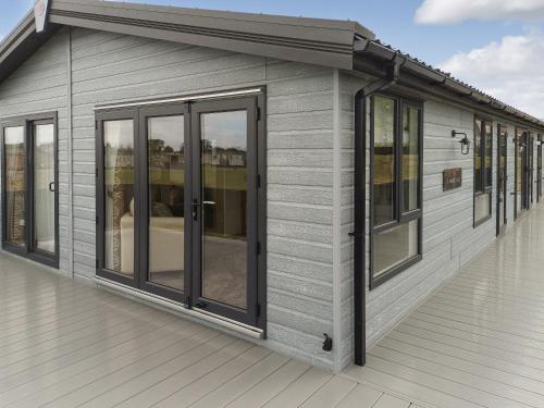 a gray house with windows on a deck at Rivendale 76 in St. Andrews