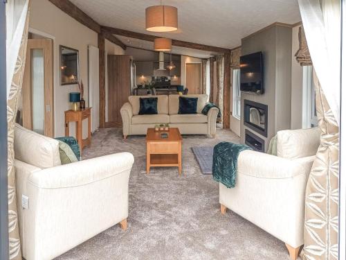 a living room with two white couches and a table at Rivendale 76 in St. Andrews