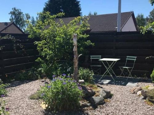 a bird perched on a pole in a garden at Snowy Owl Lodge-Ukc5065 in Aviemore