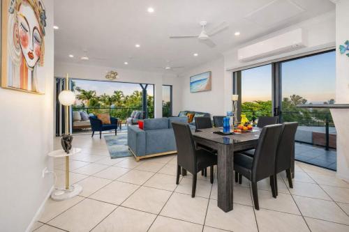 a dining room and living room with a table and chairs at 3BR Oceanfront Penthouse on The Strand, Townsville in North Ward