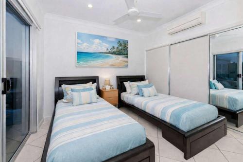 a bedroom with two beds in a room with a window at Ocean-View Penthouse on The Strand, Townsville - 3 Bedrooms in North Ward