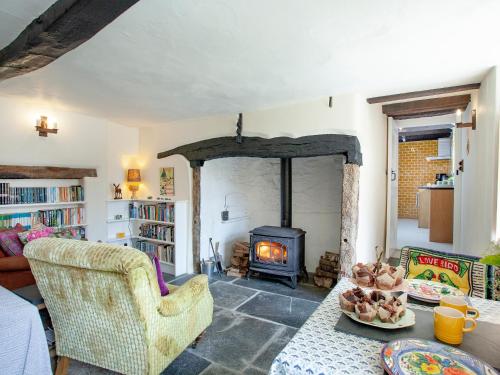 a living room with a fireplace and a table at The North Wing - Ukc6794 in Saint Gennys