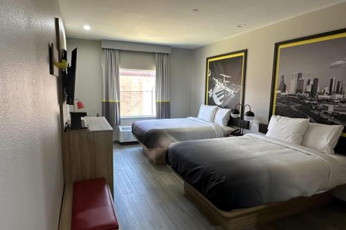 a hotel room with two beds and a window at Super 8 by Wyndham Baytown in Baytown