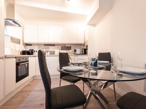 a dining room with a glass table and black chairs at Flat 1-Uk41147 in Southampton