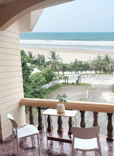 a balcony with a table and chairs and the beach at KODO Guest House in Nathon Bay