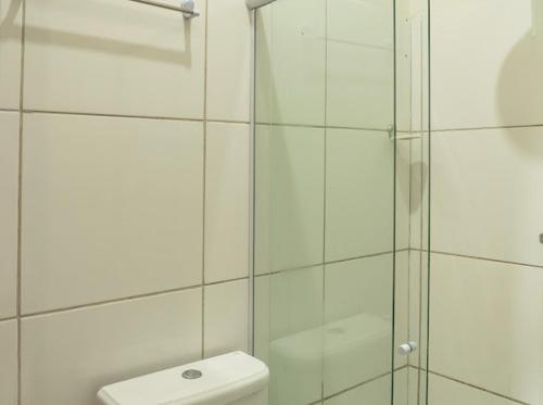 a bathroom with a glass shower and a toilet at Flat dboa in Jericoacoara