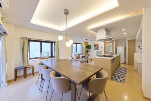 a kitchen and living room with a wooden table and chairs at Shinagawa Villa in Tokyo