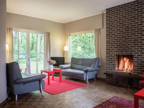 uma sala de estar com duas cadeiras e uma lareira em This atmospheric holiday home em Zoersel