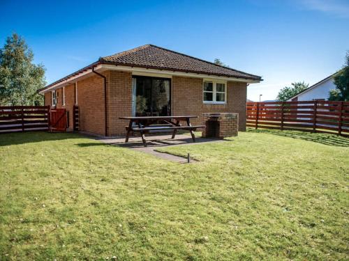 a house with a picnic table in the yard at The Cairngorm - Ukc5051 in Aviemore