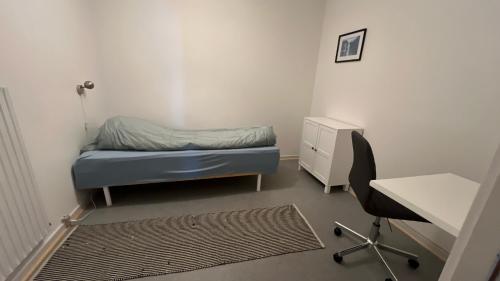 a bedroom with a bed and a desk and a chair at Whaletours Center Apartment in Ilulissat