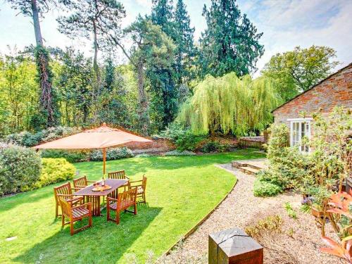 a table and chairs with an umbrella in a yard at Symond House-Ukc5530 in Bury Saint Edmunds