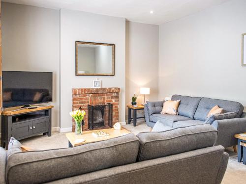 a living room with two couches and a fireplace at Symond House-Ukc5530 in Bury Saint Edmunds